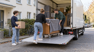 Junge Umzugshelfer verladen eine Kommode in einen LKW